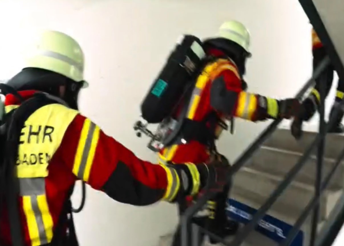 Feuerwehrleute mit Atemschutz beim Treppenaufstieg