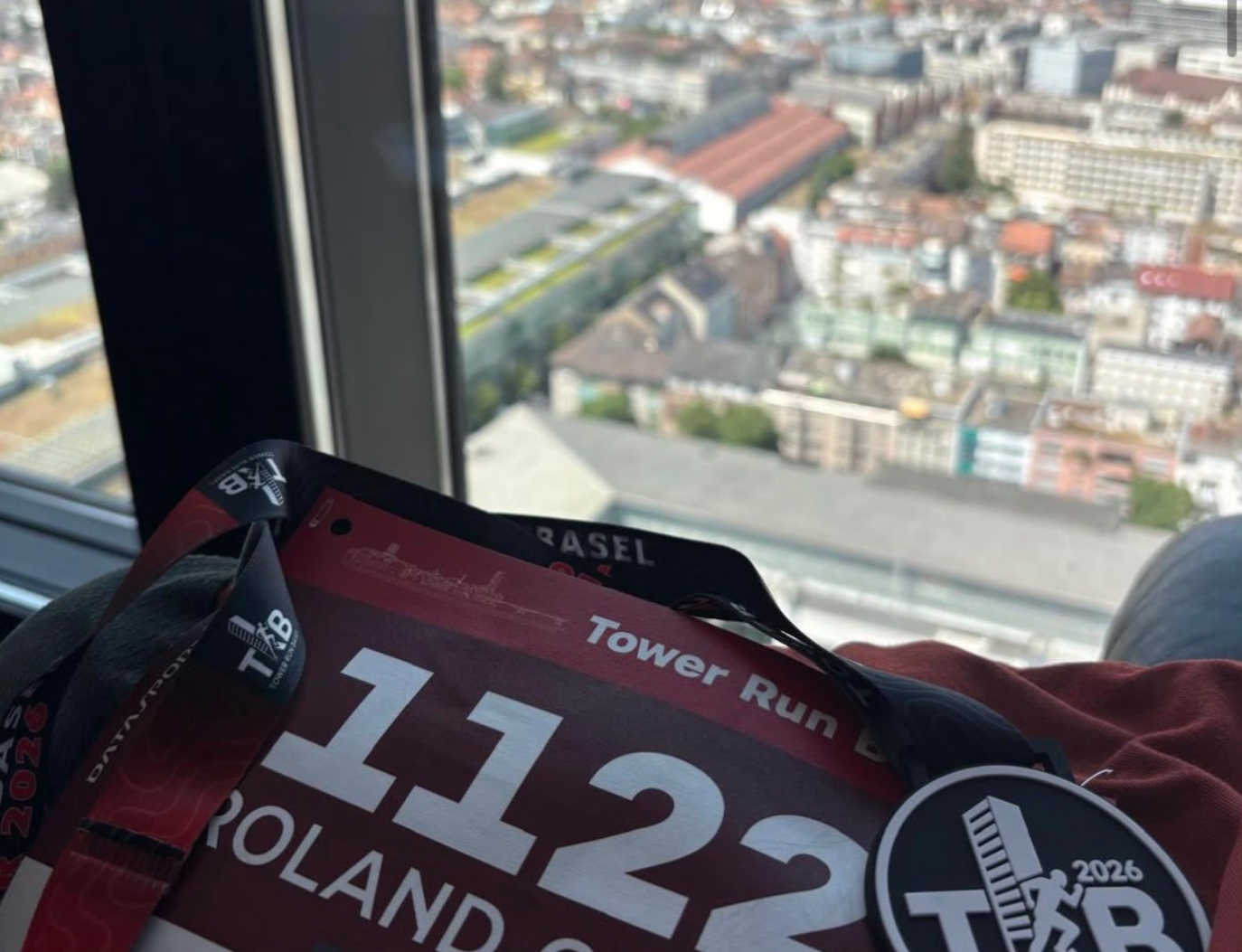 Finishermedaille und Startnummer mit Aussicht auf Basel